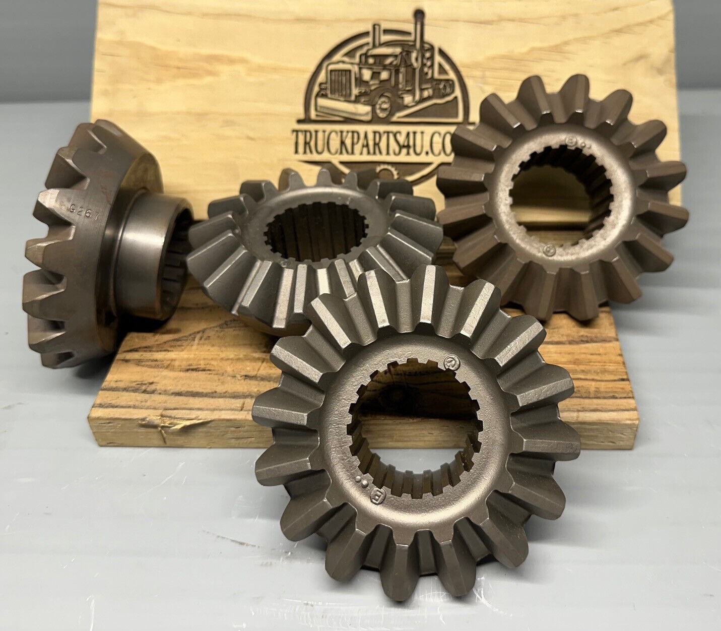 2234G267 Meritor/Rockwell/AxleTech axle side gear, 1.875 in — 20 spline, new genuine OEM; multiple gears displayed on wood block for reference