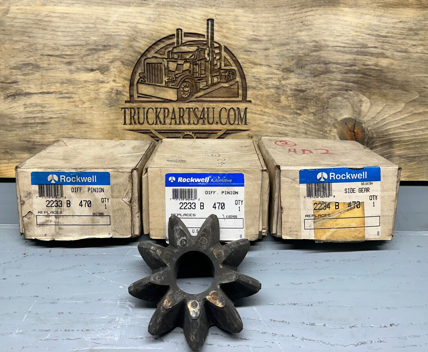 2233B470 Meritor-Rockwell-AxleTech differential pinion gear – new genuine OEM shown with original Rockwell boxes on TruckParts4U.com burnt board
