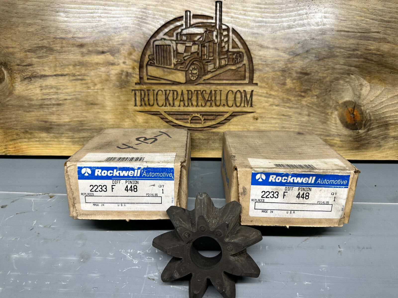 2233F448 Meritor-Rockwell-AxleTech differential pinion gear – new genuine OEM shown with original Rockwell boxes on TruckParts4U.com burnt board