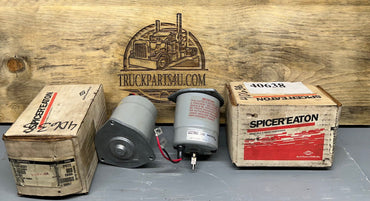 Two Eaton/Dana-Spicer 24V 2-speed diff-lock shift motors (40638 / 040638) posed with OEM boxes, cross-ref Fasco 2807-508-023, New Old Stock genuine parts