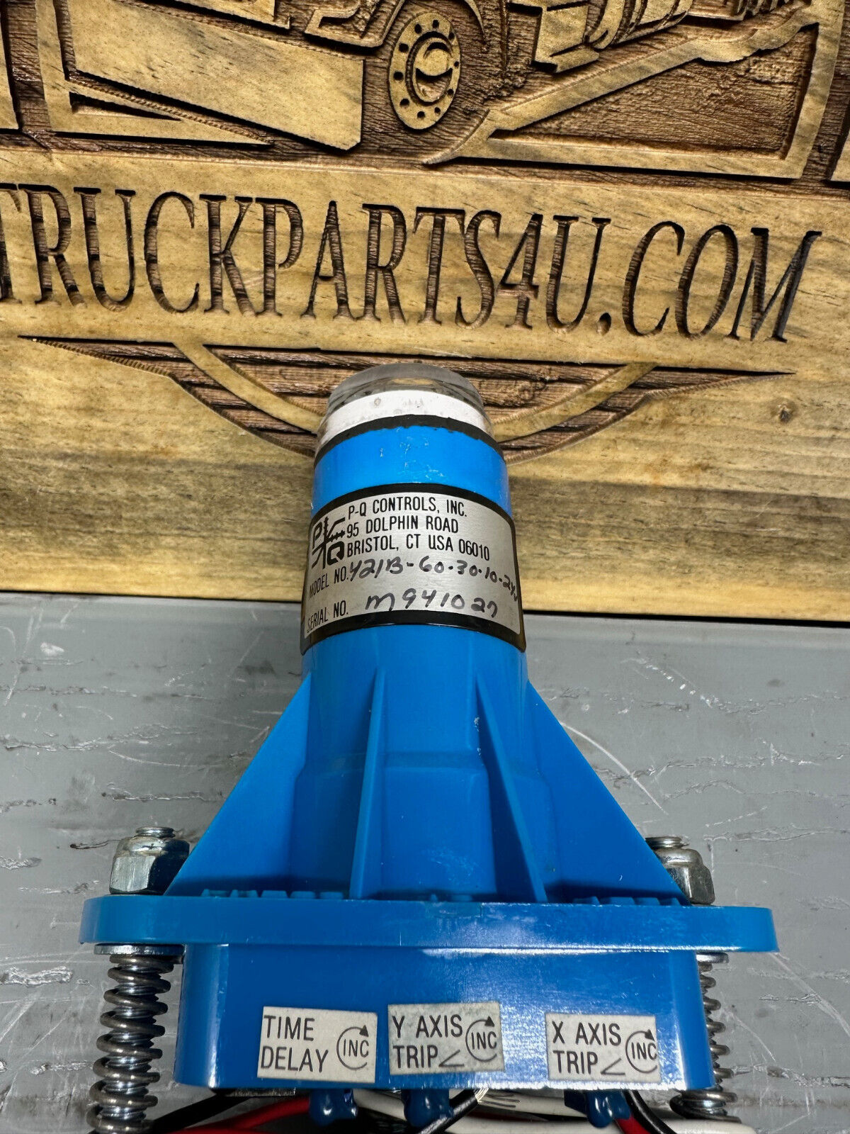 Side view of P-Q Controls M421-60-30-10-24V di-axial level sensor showing robust housing, wiring leads, and mounting features. 24V industrial slope sensor for pitch and roll control in aerial lifts and heavy equipment.