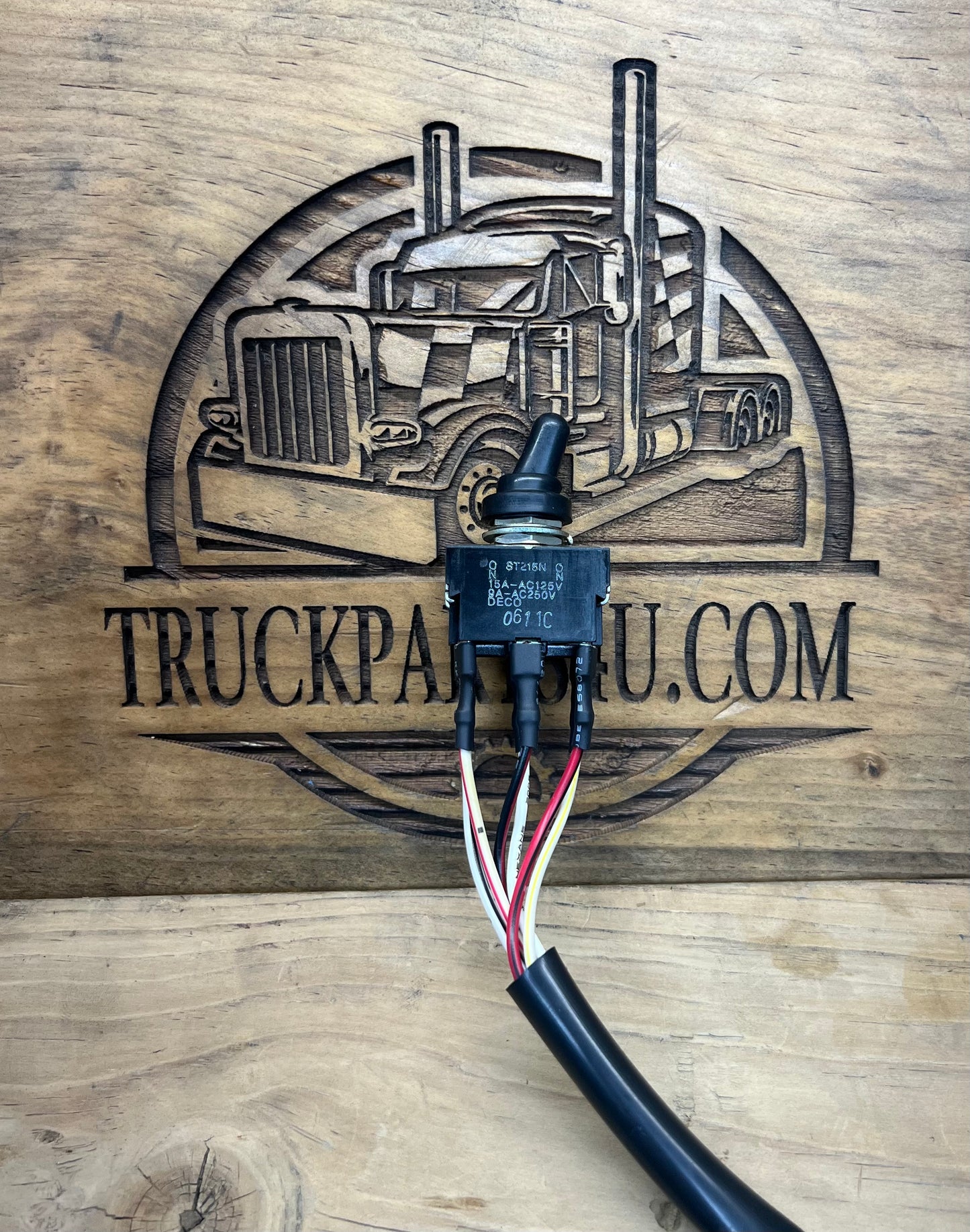 Front view of genuine Volvo CE 14526156 toggle switch assembly with rubber boot, wiring leads, and attached harness